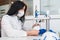 A woman works at a machine for the manufacture of medical masks with nanofibre and solder loops to them with ultrasound.