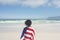 Woman wrapped american flag at beach