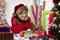 Woman wrapping Christmas presents, looking exhausted.