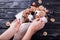 Woman wraps sweet eatable bouquet wrapped in paper on black background