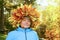 A woman with a wreath of yellow maple leaves on her head