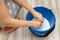 woman wringing out a rag in a bucket of water while cleaning