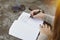 Woman Writes Down Her Life Goals in a Journal with Sunglasses and a Phone on a Table