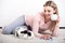 Woman writes a letter in a romantic home atmosphere, lying on the carpet with a rabbit.