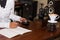 Woman writes a noteped on a wooden table.