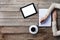 Woman writes on a paper with screen of digital tablet next to her