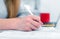 A woman writes while sitting at a table in an office or classroom. The girl fills the documents at the workplace using a