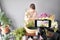 A woman writes a video blog or online course. Flower school concept. Florist woman creates flower arrangement in a