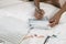 Woman Writing cheque on bed by laptop close up of hands high angle view