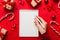 Woman writing Christmas to do list on notebook on colored background with xmas decorations