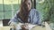 Woman writing in journal in cafe, learning.