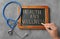 Woman writing phrase Health and wellness on blackboard