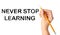 Woman writing phrase NEVER STOP LEARNING on background, closeup. Banner design