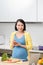 Woman writing shopping list on kitchen