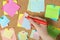 Woman writing on sticky note pinned to corkboard, closeup