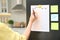 Woman writing to do list on refrigerator door in kitchen