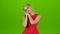 Woman yawns covering her mouth with hands. Green screen studio