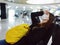 a woman with a yellow backpack sits at the airport long waiting for a flight