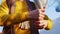 Woman in yellow clothes wrings towel hanging on rope closeup