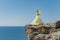 Woman in a yellow dress on the sea. Side view Young beautiful sensual woman in yellow long dress posing on a rock high