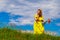 Woman in a yellow dress shows her tongue in a field in nature. Great mood concept