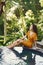 Woman in a yellow dress sitting by the pool in Bali