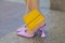 Woman with yellow and golden Jacquemus leather bag and purple glitter high heel shoes before