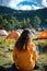 Woman in yellow jacket sitting at a campsite with tents.