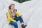 Woman in yellow raincoat hiking in white mountains