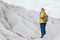 Woman in yellow raincoat hiking in white mountains