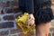 Woman with yellow reptile leather Valentino bag and black skirt before Salvatore Ferragamo
