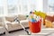 Woman in yellow rubber gloves holding in hand cleaning products in orange  bucket in living room at home, copy space. Housework.