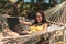 A woman in a yellow swimsuit lying in a hammock using a laptop