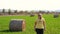 Woman in yellow waling in field of bales