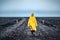 Woman in yellow walks through a wild desert road in Iceland. Wilderness in Iceland