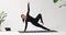 Woman yoga instructor performs a variation of Vasishthasana exercise, side plank with leg extended