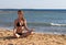 Woman in yoga lotus meditation back to seaside