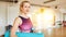 Woman with yoga mat in classroom of fitness center