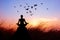 Woman yoga and meditating, silhouette on nature sunset