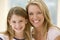 Woman and young girl in living room smiling