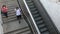 Woman and young man going down the metro station stairs wearing protective masks