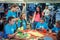 Woman â€“ journalist interviewing teen girls, participating in making colorful paper flowers workshop