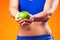 Womanin sportswear holding an apple. People, fitness and healthcare concept