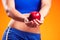 Womanin sportswear holding an apple. People, fitness and healthcare concept