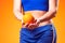 Womanin sportswear holding orange fruit. People, fitness and healthcare concept