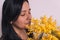 Womans day mimosa. closeup of young woman smelling yellow mimosa flowers bouquet on white background smiling with casual clothes