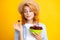 Womans enjoying a fresh sweet cherry. Female eating cherries on yellow background.