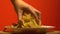 Womans hand grabbing chips from plate, home party with junk food, slow motion