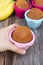 Womans hand holding banana cake in colorful baking pan.