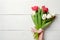 Womans hand holding Bouquet of tulips on white wooden horizontal striped board. Greeting card for International Womans Day, Mother